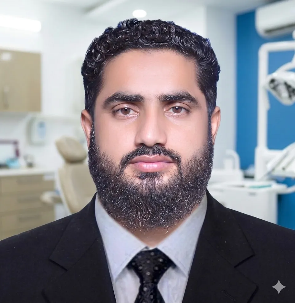 Portrait of Dr. Hassan in a dark suit and tie at the clinic